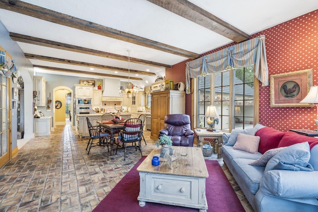 living room featuring a notable chandelier and beam ceiling