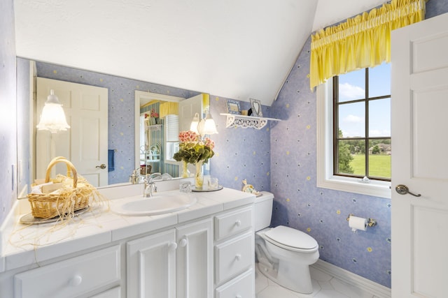 bathroom with vanity, lofted ceiling, toilet, and tile patterned floors