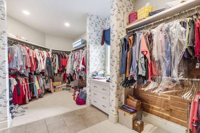 spacious closet featuring light colored carpet