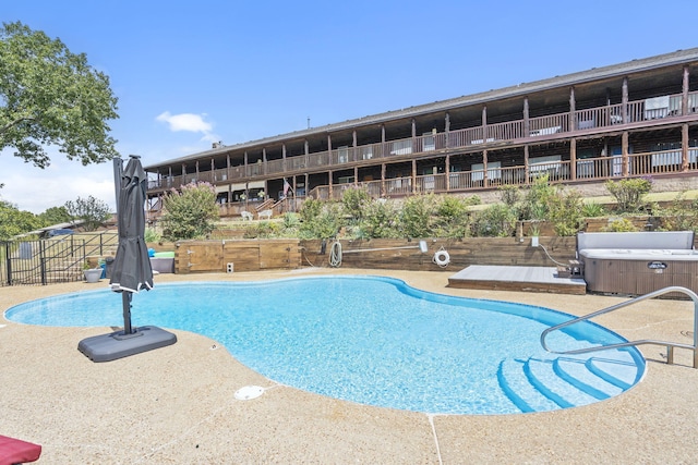 view of swimming pool with a hot tub