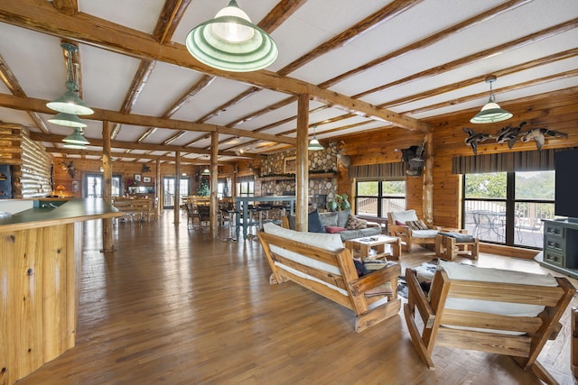 living room with wood walls, beamed ceiling, and dark hardwood / wood-style flooring