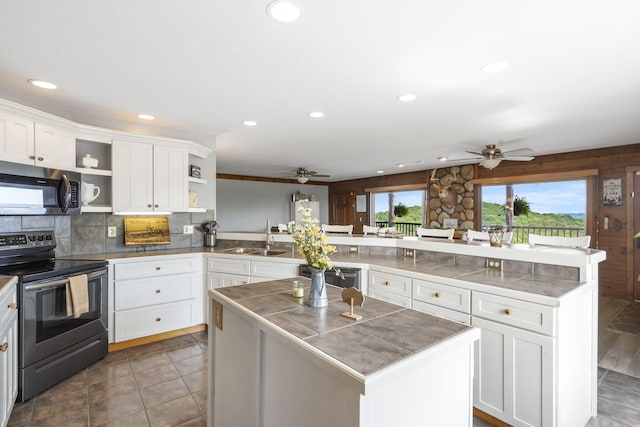 kitchen with kitchen peninsula, sink, stainless steel appliances, and white cabinets