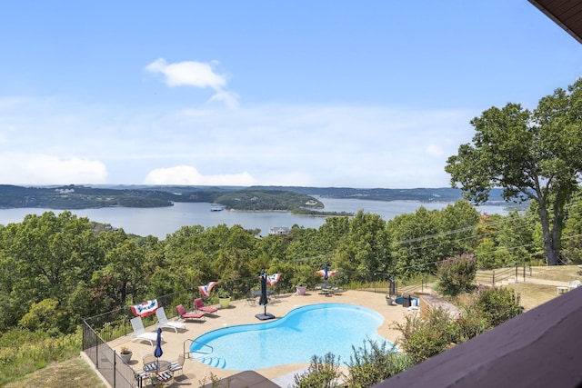 view of pool with a water view and a patio