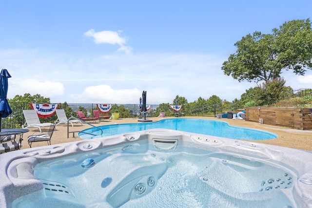 view of swimming pool with a patio and a hot tub