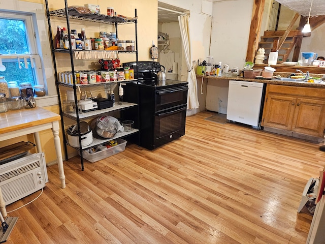 kitchen with sink, hanging light fixtures, white dishwasher, light hardwood / wood-style flooring, and black range with electric cooktop