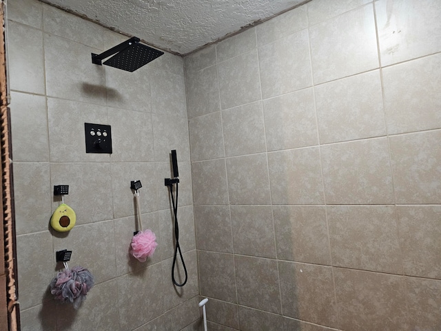 bathroom with tiled shower and a textured ceiling