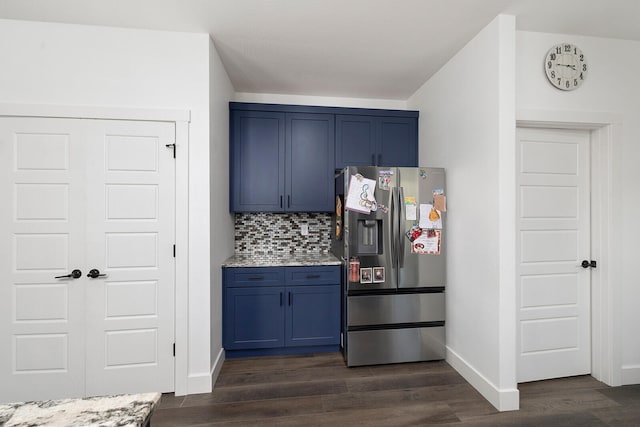 kitchen featuring blue cabinets, tasteful backsplash, dark wood-type flooring, light stone countertops, and stainless steel refrigerator with ice dispenser