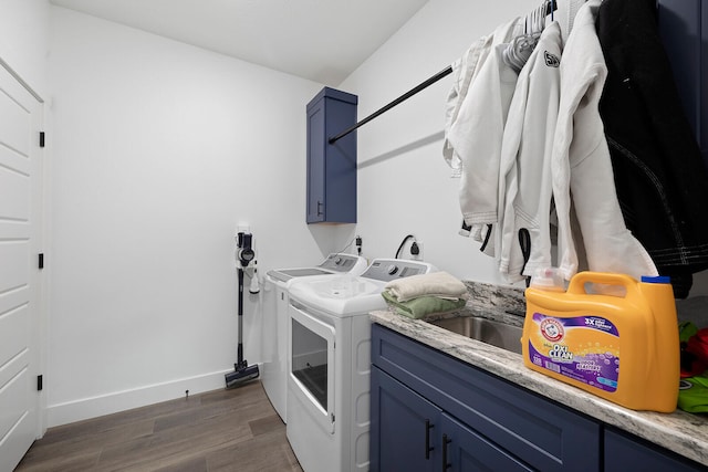 laundry room with independent washer and dryer, dark hardwood / wood-style floors, and cabinets