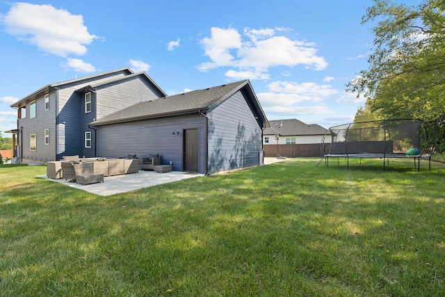 back of house with a trampoline, a patio, a lawn, and an outdoor hangout area