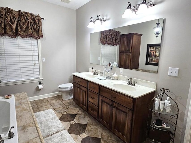 bathroom featuring a bath, vanity, and toilet