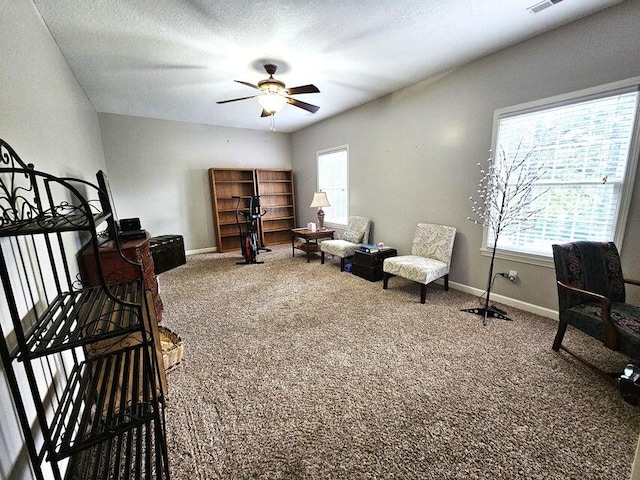 sitting room featuring ceiling fan, carpet floors, and a textured ceiling