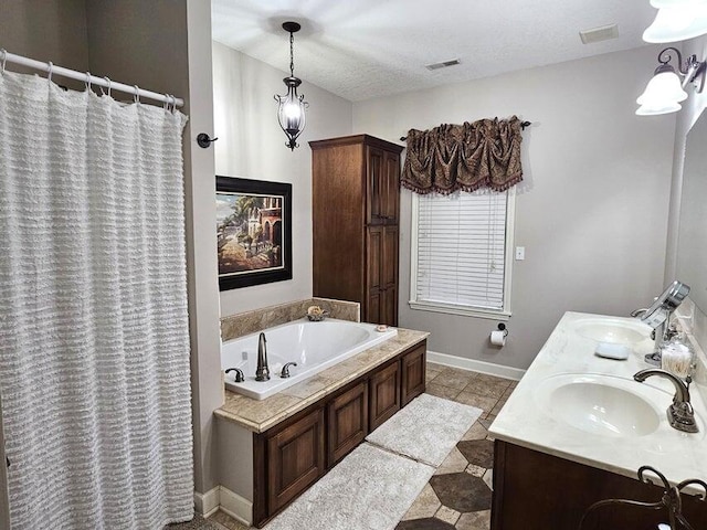 bathroom with a bathtub, tile patterned floors, vanity, and a textured ceiling