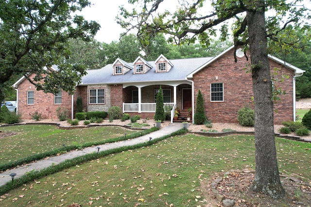 cape cod-style house featuring a porch and a front lawn