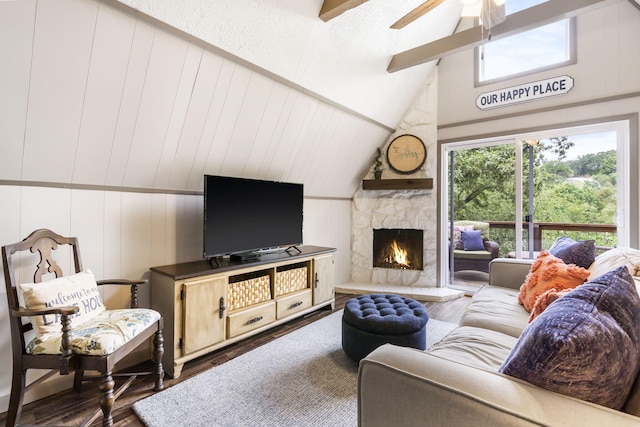 living room featuring high vaulted ceiling, ceiling fan, a stone fireplace, dark hardwood / wood-style flooring, and wood walls