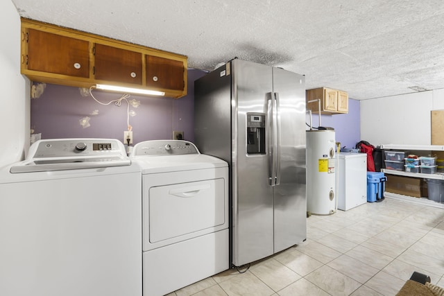 clothes washing area featuring electric water heater, independent washer and dryer, a textured ceiling, and cabinets