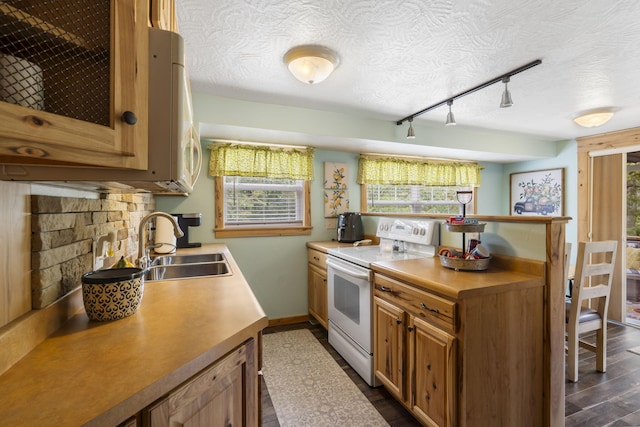 kitchen with rail lighting, white appliances, dark wood-type flooring, sink, and a textured ceiling