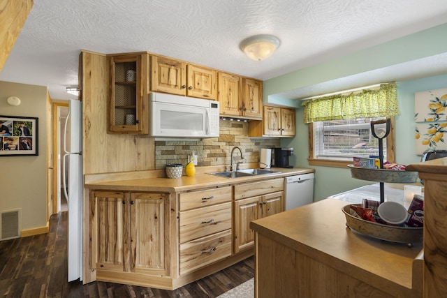 kitchen with decorative backsplash, dark wood-type flooring, white appliances, sink, and a textured ceiling