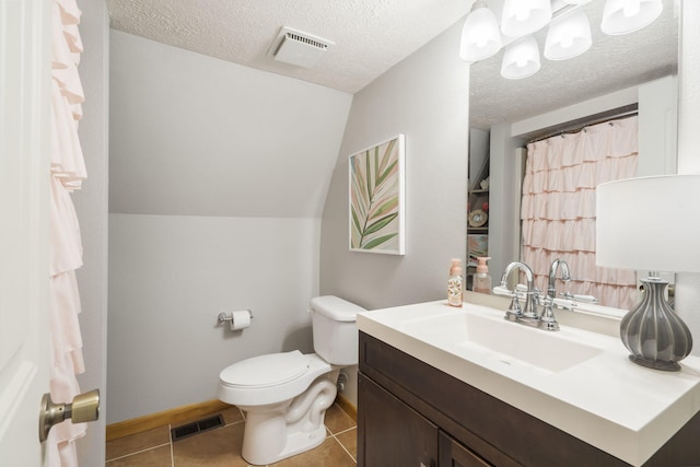 bathroom featuring toilet, vaulted ceiling, tile patterned floors, vanity, and a textured ceiling