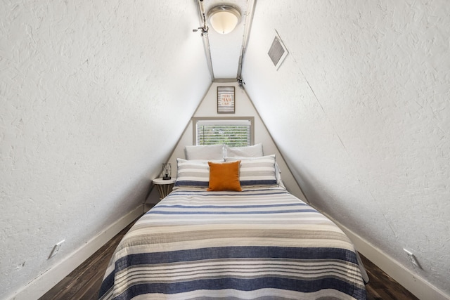 bedroom with vaulted ceiling and hardwood / wood-style floors