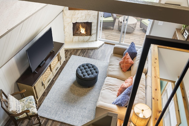 living room featuring wooden walls, a fireplace, and dark hardwood / wood-style floors