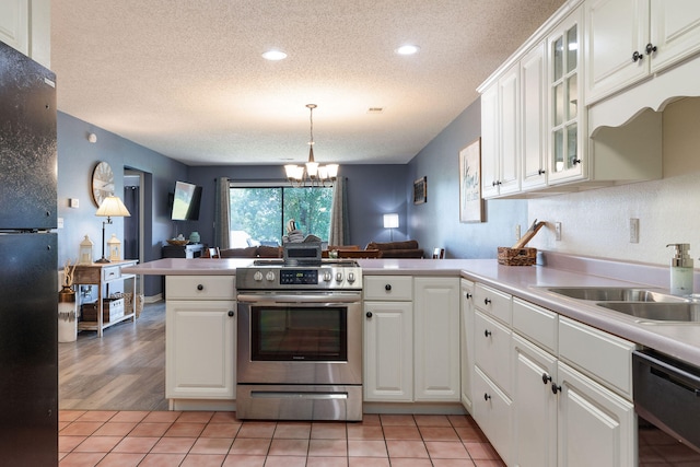 kitchen featuring light hardwood / wood-style flooring, sink, kitchen peninsula, black appliances, and white cabinetry