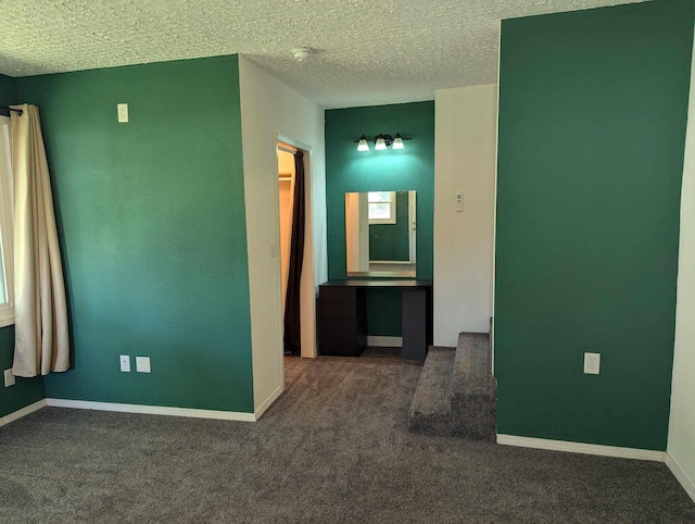 carpeted empty room with a textured ceiling