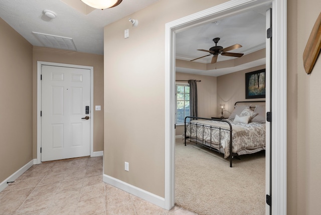 carpeted bedroom featuring ornamental molding and a raised ceiling