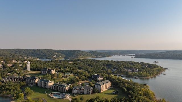 aerial view at dusk featuring a water view