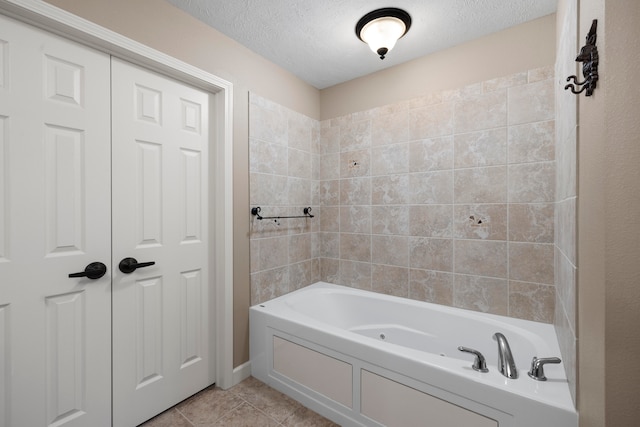 bathroom with tile patterned floors, a textured ceiling, and a tub to relax in