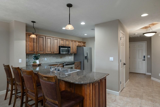 kitchen with pendant lighting, sink, backsplash, kitchen peninsula, and stainless steel appliances