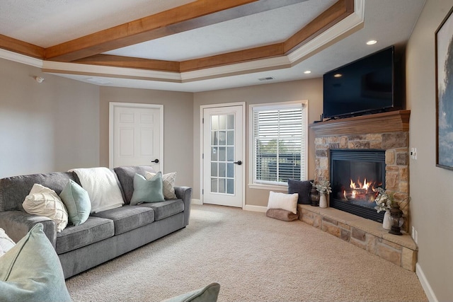 carpeted living room featuring a fireplace and a raised ceiling