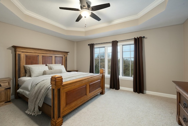 bedroom with ornamental molding, light colored carpet, a raised ceiling, and ceiling fan