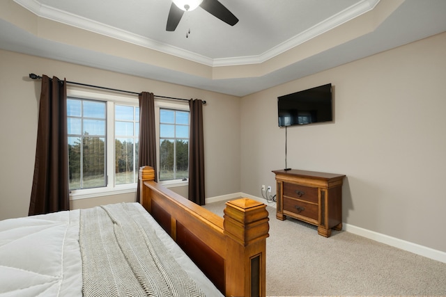 carpeted bedroom with crown molding, ceiling fan, and a tray ceiling