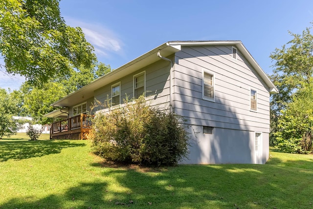 view of property exterior with a deck and a lawn