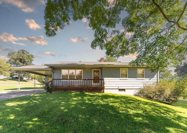 view of front facade with a front yard, a deck, and a carport