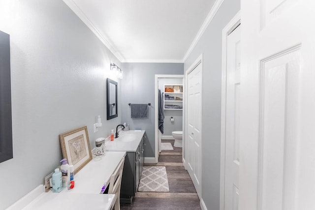 bathroom featuring ornamental molding, hardwood / wood-style flooring, vanity, and toilet