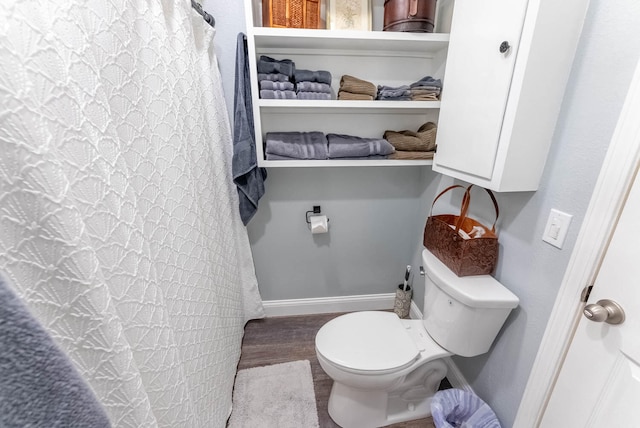 bathroom featuring walk in shower, toilet, and wood-type flooring