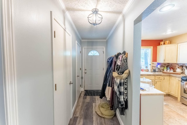 entryway with crown molding, light hardwood / wood-style flooring, a textured ceiling, and sink