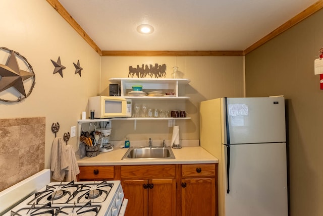 kitchen with crown molding, sink, and white appliances