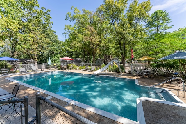 view of swimming pool with a water slide and a patio