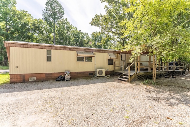 rear view of house with ac unit and a wooden deck