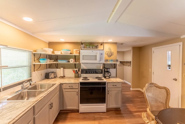 kitchen with lofted ceiling with beams, hardwood / wood-style floors, white appliances, sink, and backsplash