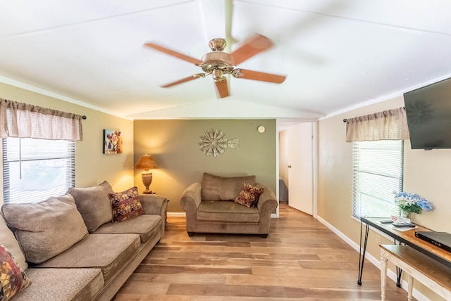 living room with ceiling fan, lofted ceiling, a wealth of natural light, and light hardwood / wood-style floors