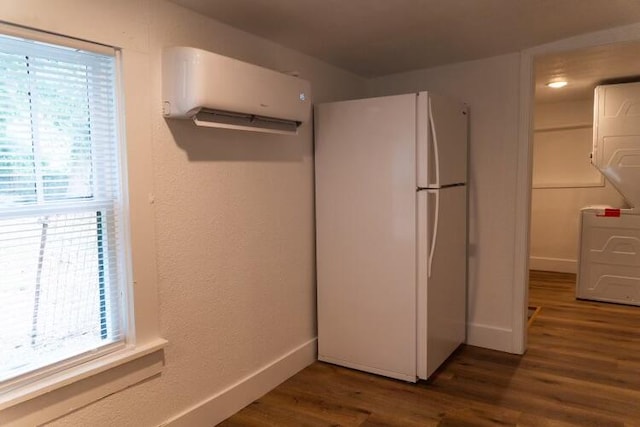 kitchen with dark wood-type flooring, white refrigerator, and a wall mounted air conditioner