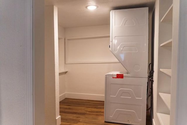 interior space with stacked washer and dryer and hardwood / wood-style flooring