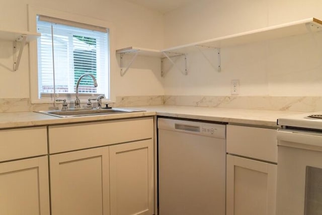 kitchen with white appliances, sink, and white cabinetry