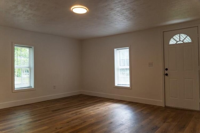 entrance foyer featuring dark wood-type flooring and a textured ceiling