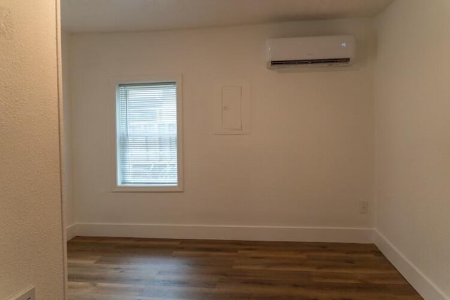 unfurnished room with dark wood-type flooring and a wall unit AC