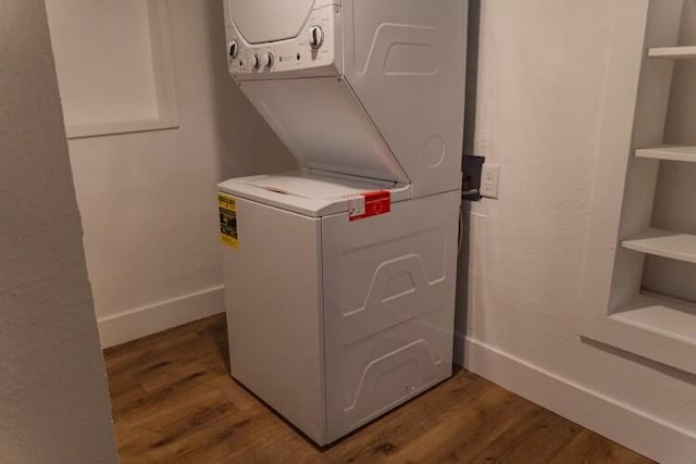 laundry room featuring hardwood / wood-style flooring and stacked washing maching and dryer