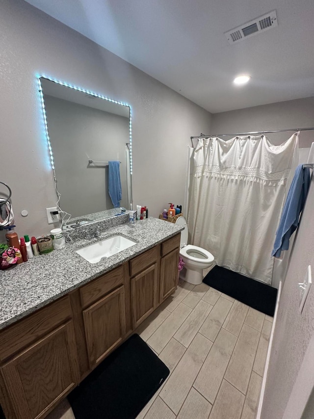 bathroom with wood-type flooring, a shower with curtain, vanity, and toilet